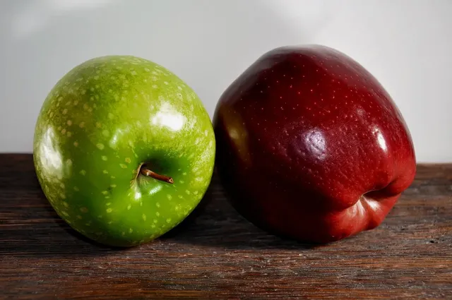 Obst und Gemüse Karotten und Äpfel auf weißem Holz. Obst und Gemüse gehört zu einer gesunden Ernährung.